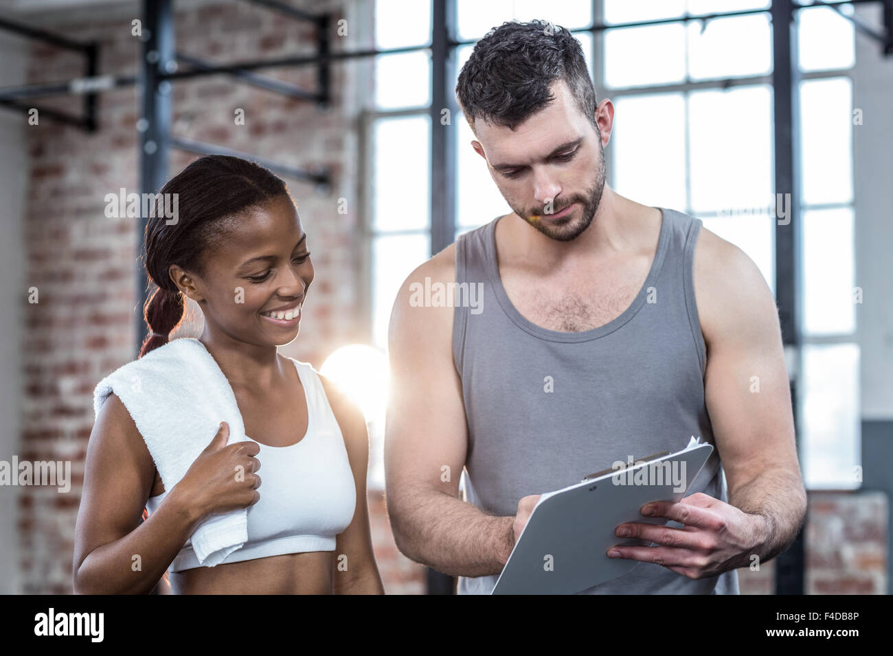 Woman discussing her performance on clipboard with a trainer Stock ...