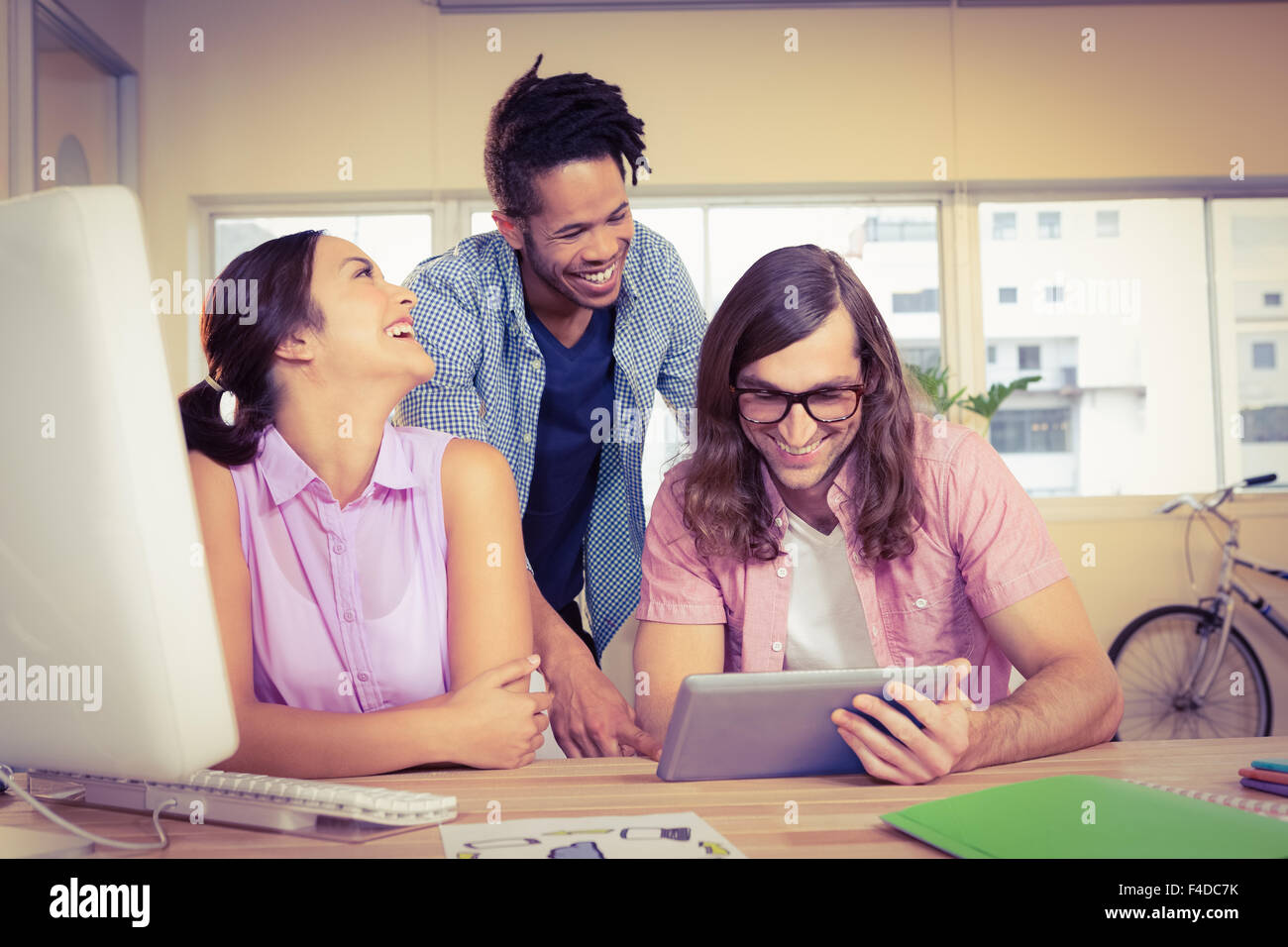 Business people smiling and discussing over digital tablet Stock Photo