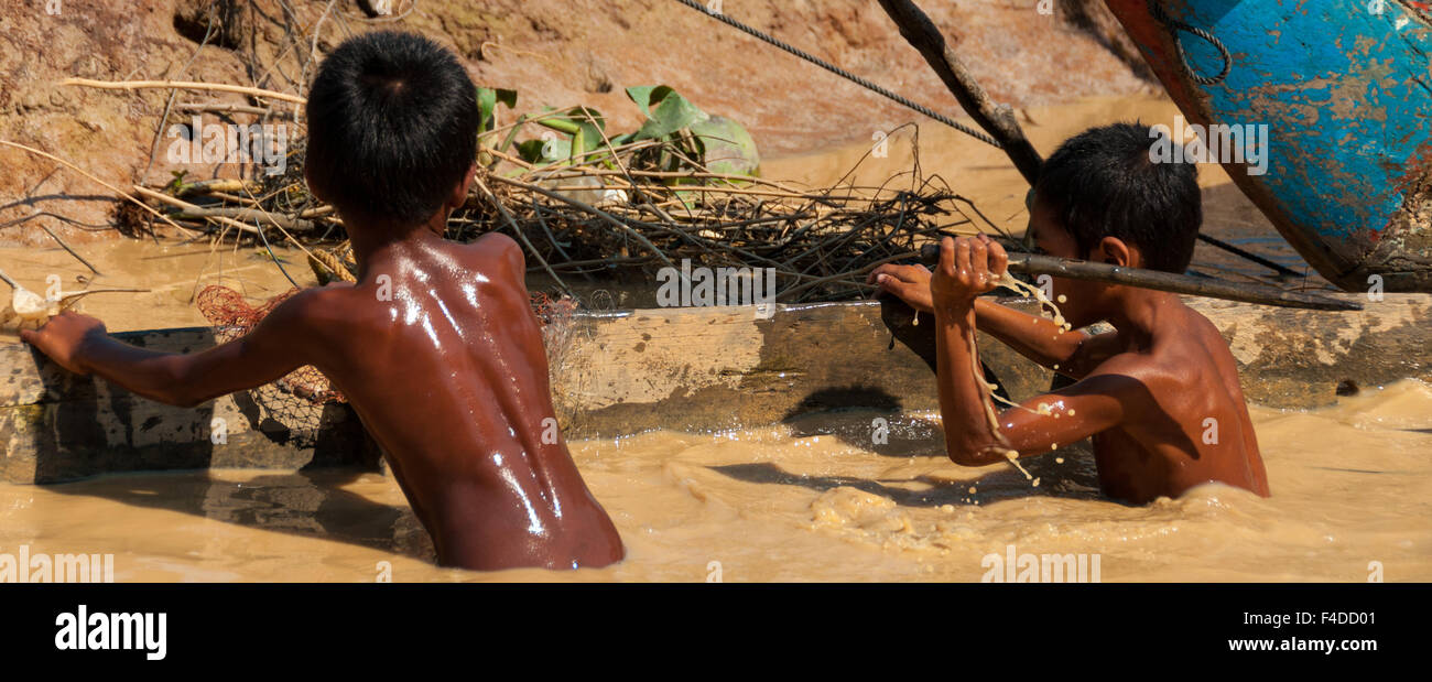 Two Asian boys playing in the mud Stock Photo