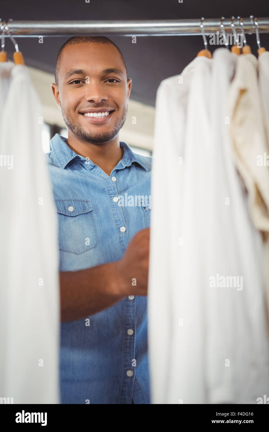 Porrait of smiling man searching for shirt at mall Stock Photo