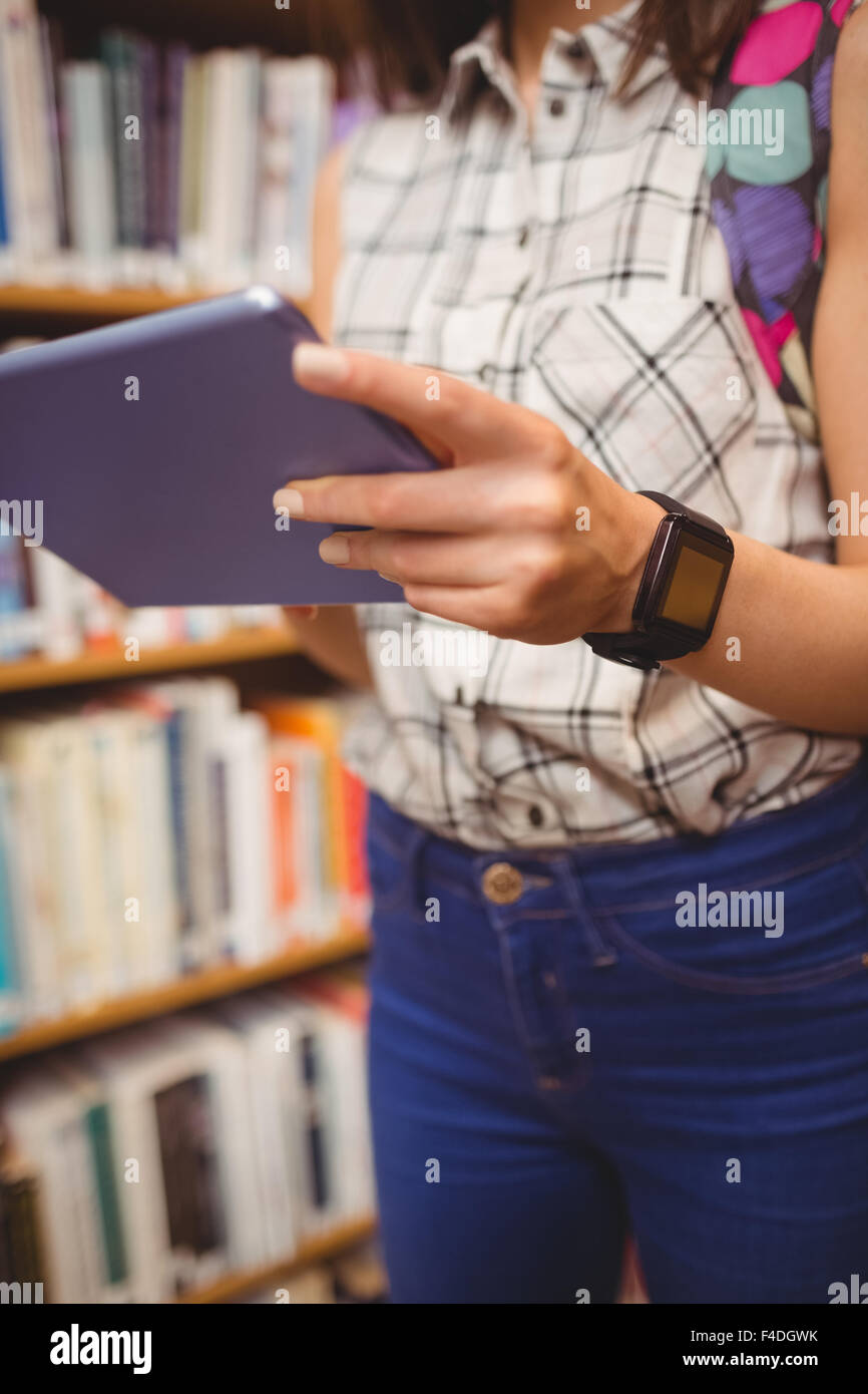 Midsection of student holding tablet and smart watch Stock Photo