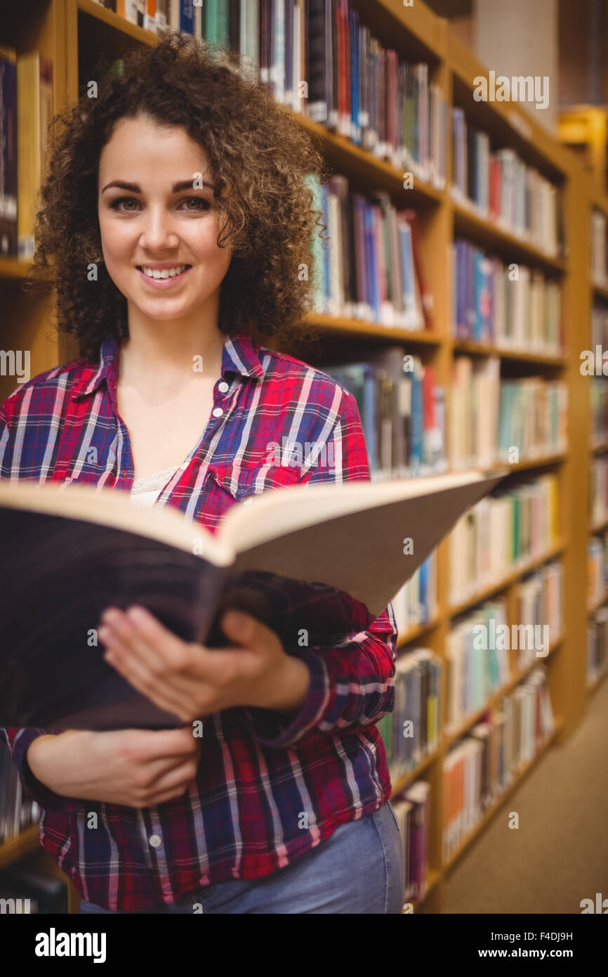 Pretty student in the library reading book Stock Photo