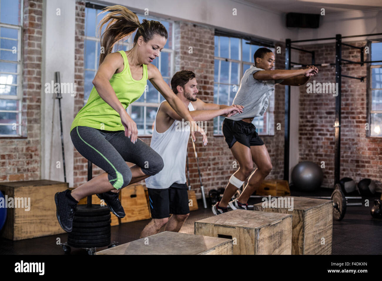 Three fit athletes doing exercises Stock Photo