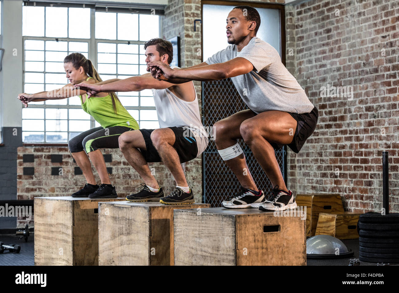 Fit people doing squat jumps Stock Photo