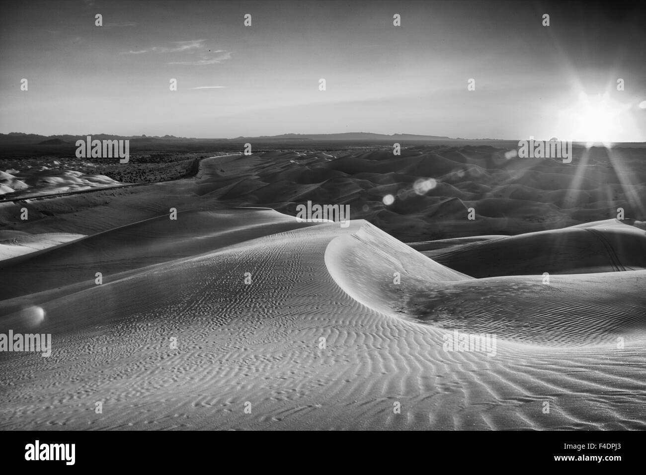 Sunrise over a stark black and white desert landscape, sand with waves of texture In the Imperial Sand Dunes near Yuma Arizona. Stock Photo