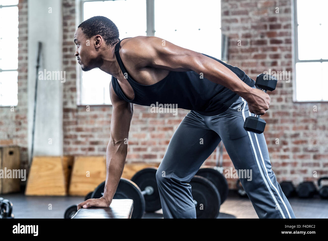 Muscular man doing dumbbell exercises Stock Photo