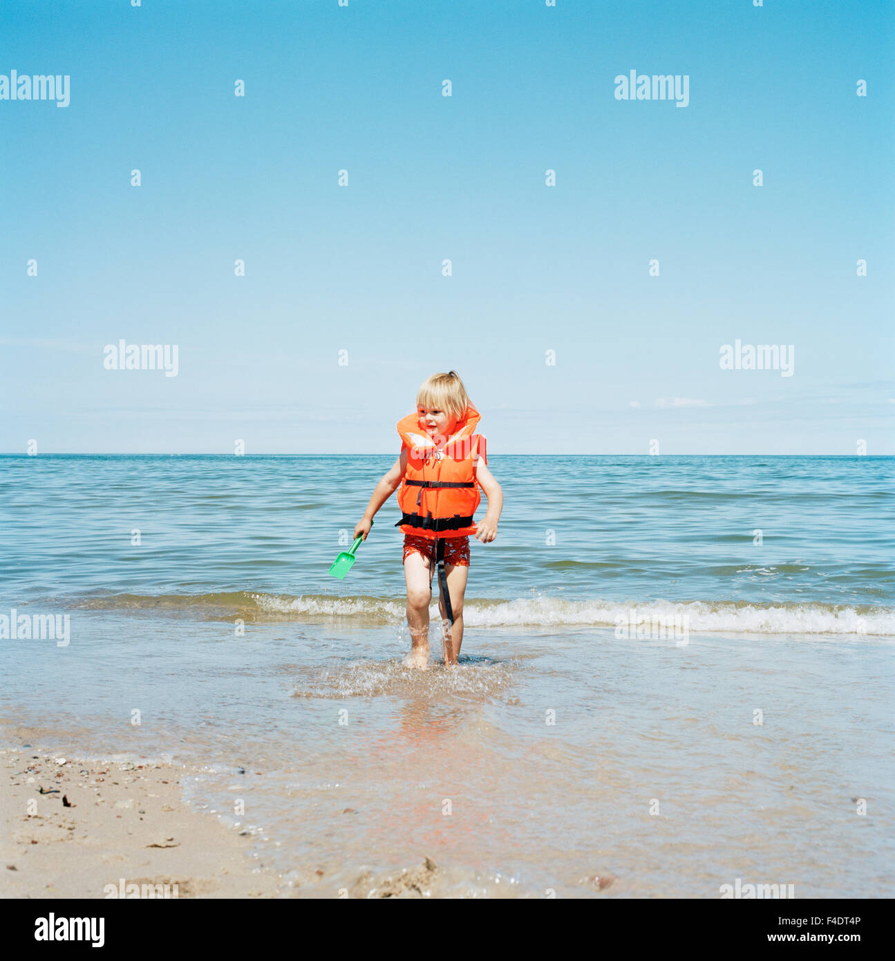 A boy wearing a life jacket swimming Stock Photo Alamy