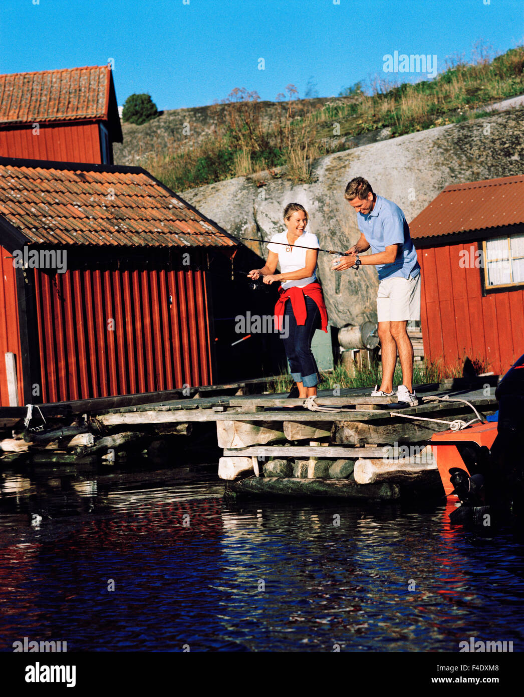 A woman and a man fishing, Harstena, Sweden. Stock Photo
