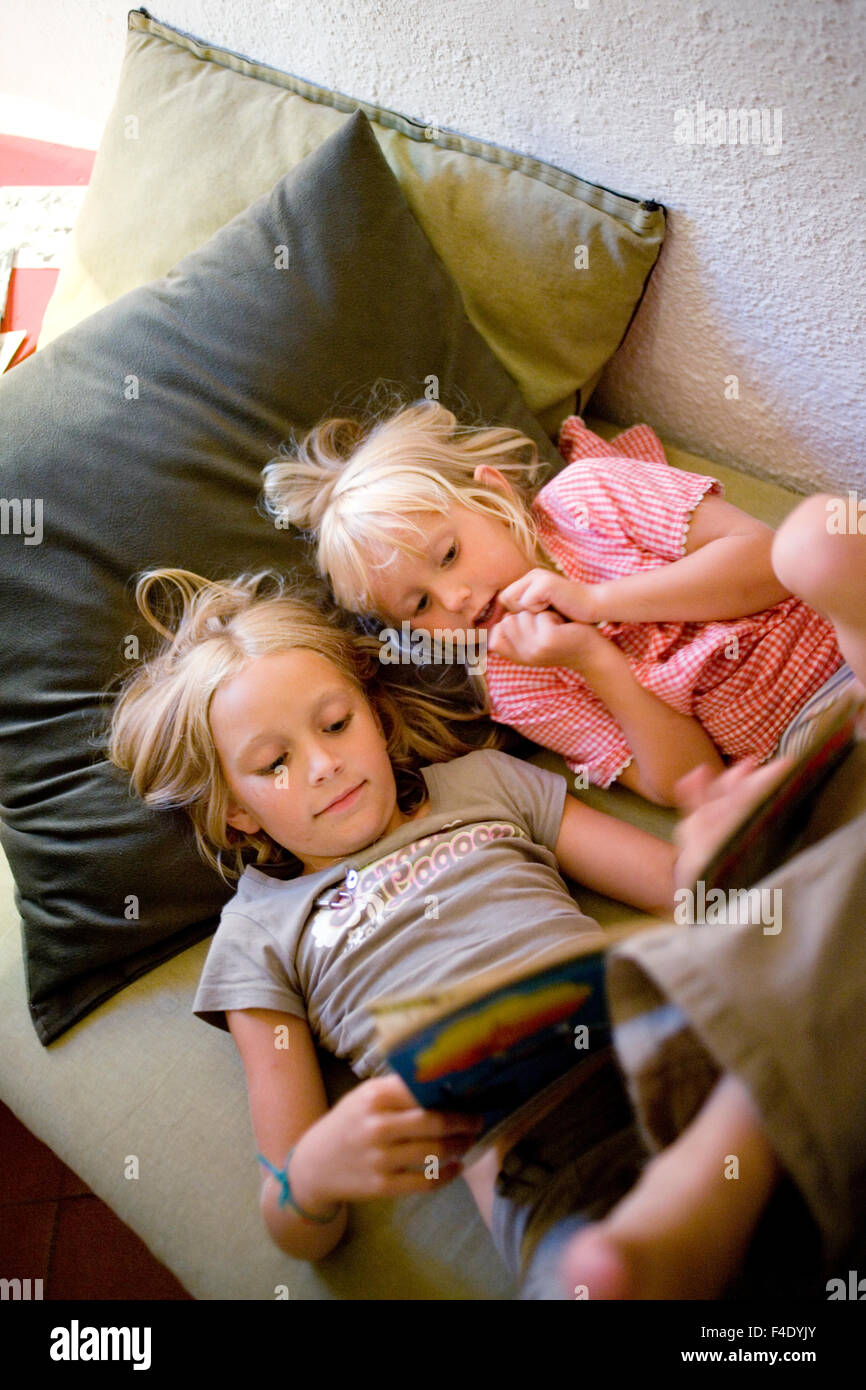 Sisters reading a book. Stock Photo
