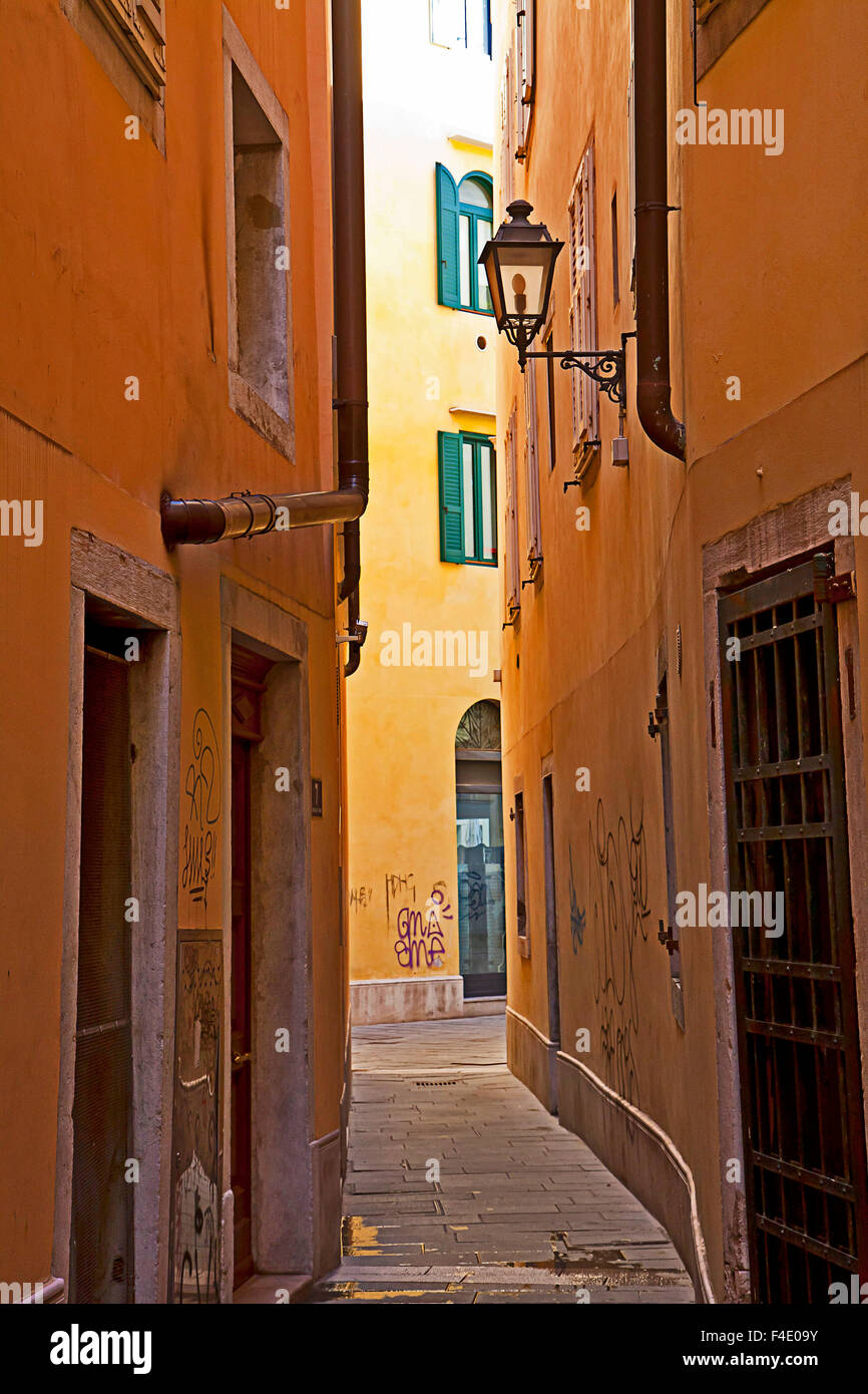 Trieste, Italy - Old town, narrow pedestrian street in the ghetto with lamp street and graffiti Stock Photo