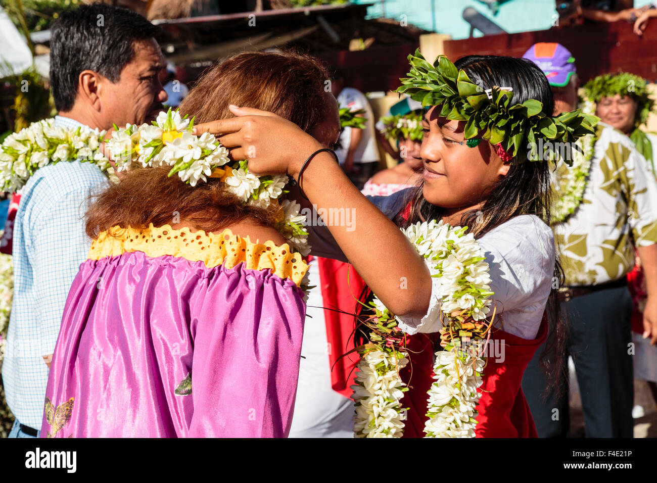 Pacific Ocean, French Polynesia, Society Islands, Huahine, Fare. Woman placing traditional lei on tourist. Stock Photo
