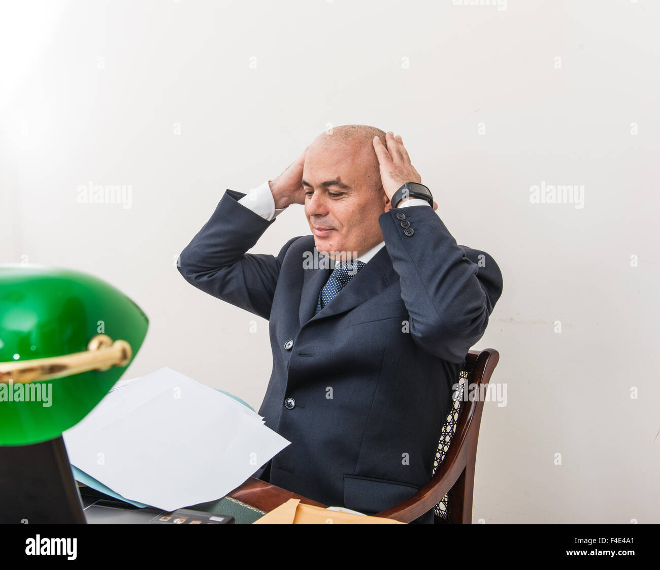 An agonising business man, in crisis,  in front of his pc. In his study, alone with his despair and his panic. Stock Photo