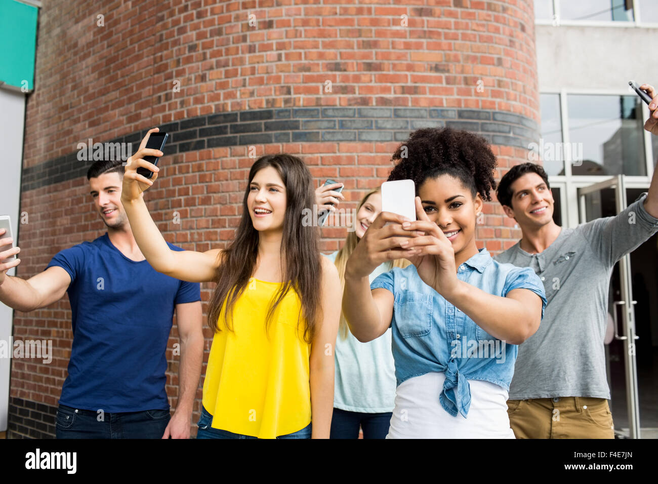 Students all taking selfies together Stock Photo