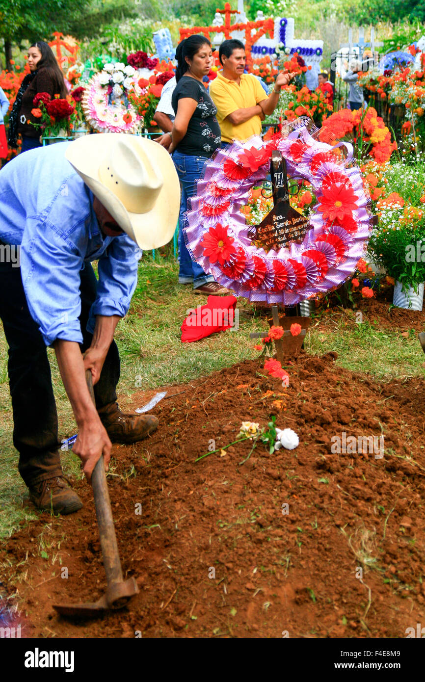 Tsin Tsun Tsan, Mexico. Family member prepares grave for celebration. Stock Photo