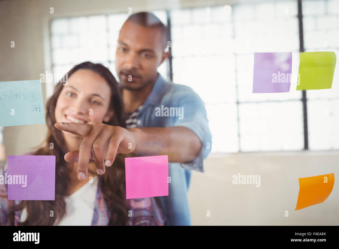 Man showing sticky note to woman Stock Photo
