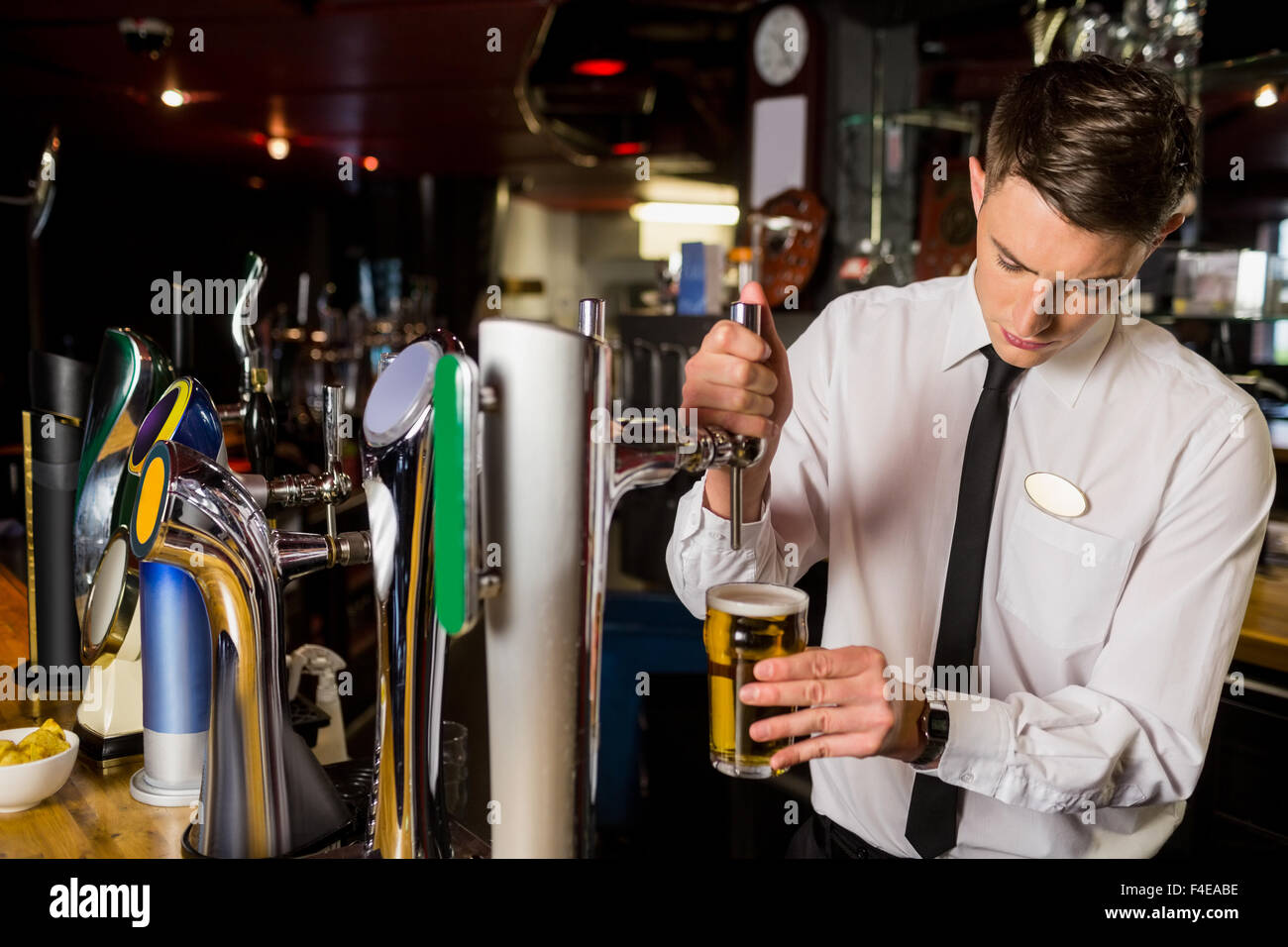 Well dressed bartender serving beer Stock Photo