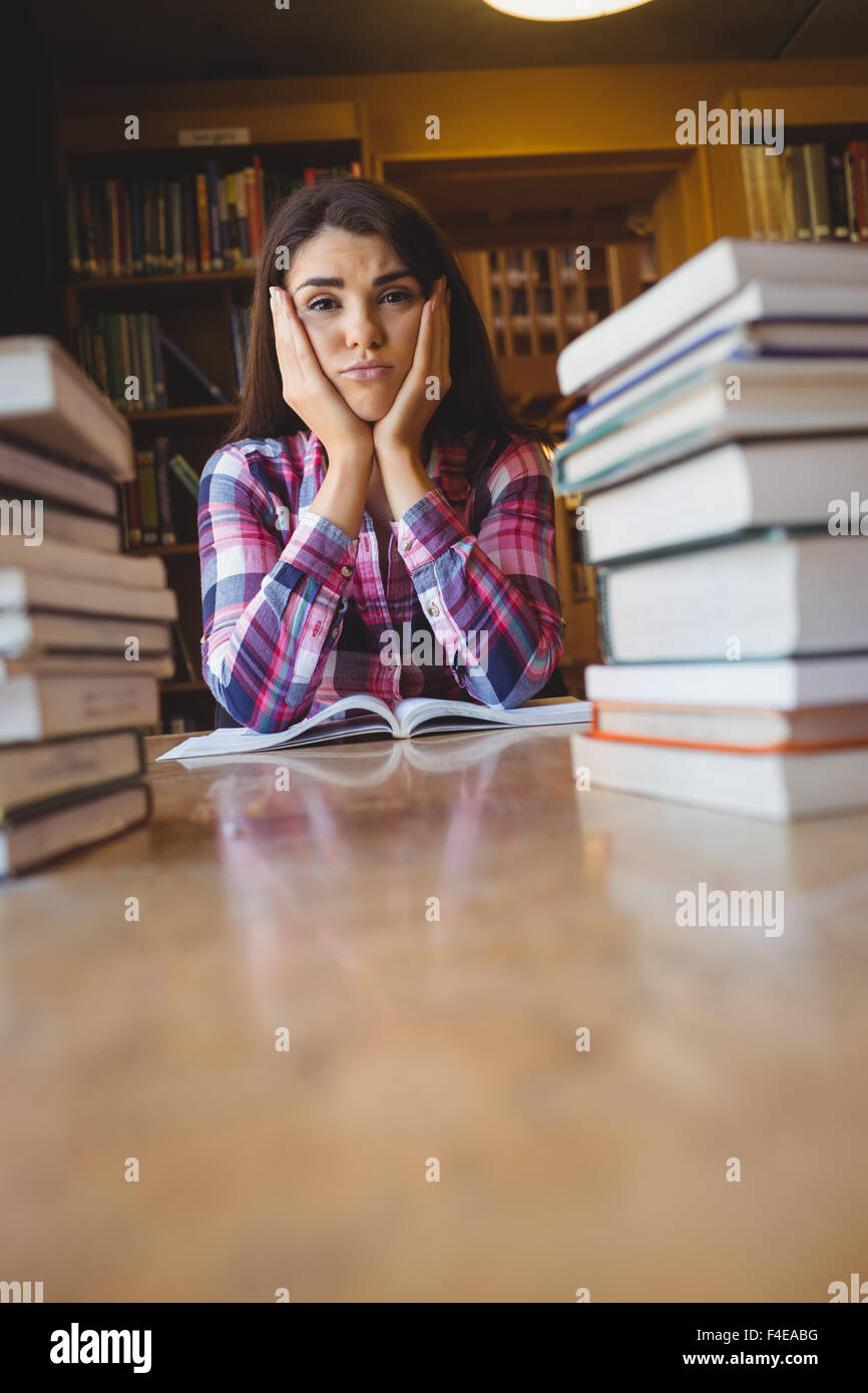 Portrait of frustrated female student at table Stock Photo