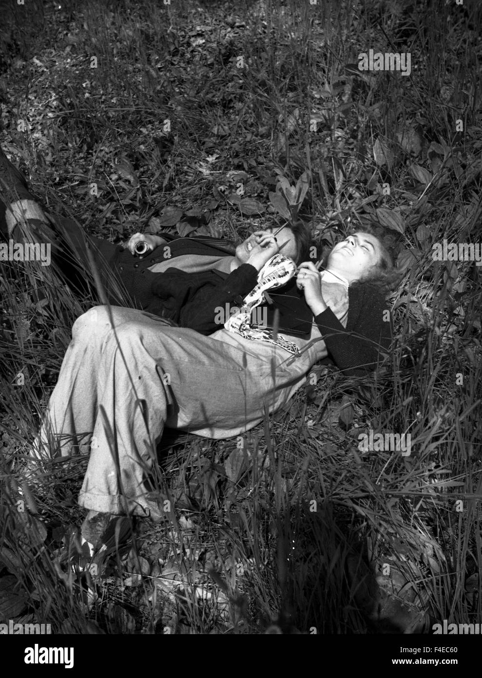 high school or college sweethearts laying in the grass during the 1940s Stock Photo