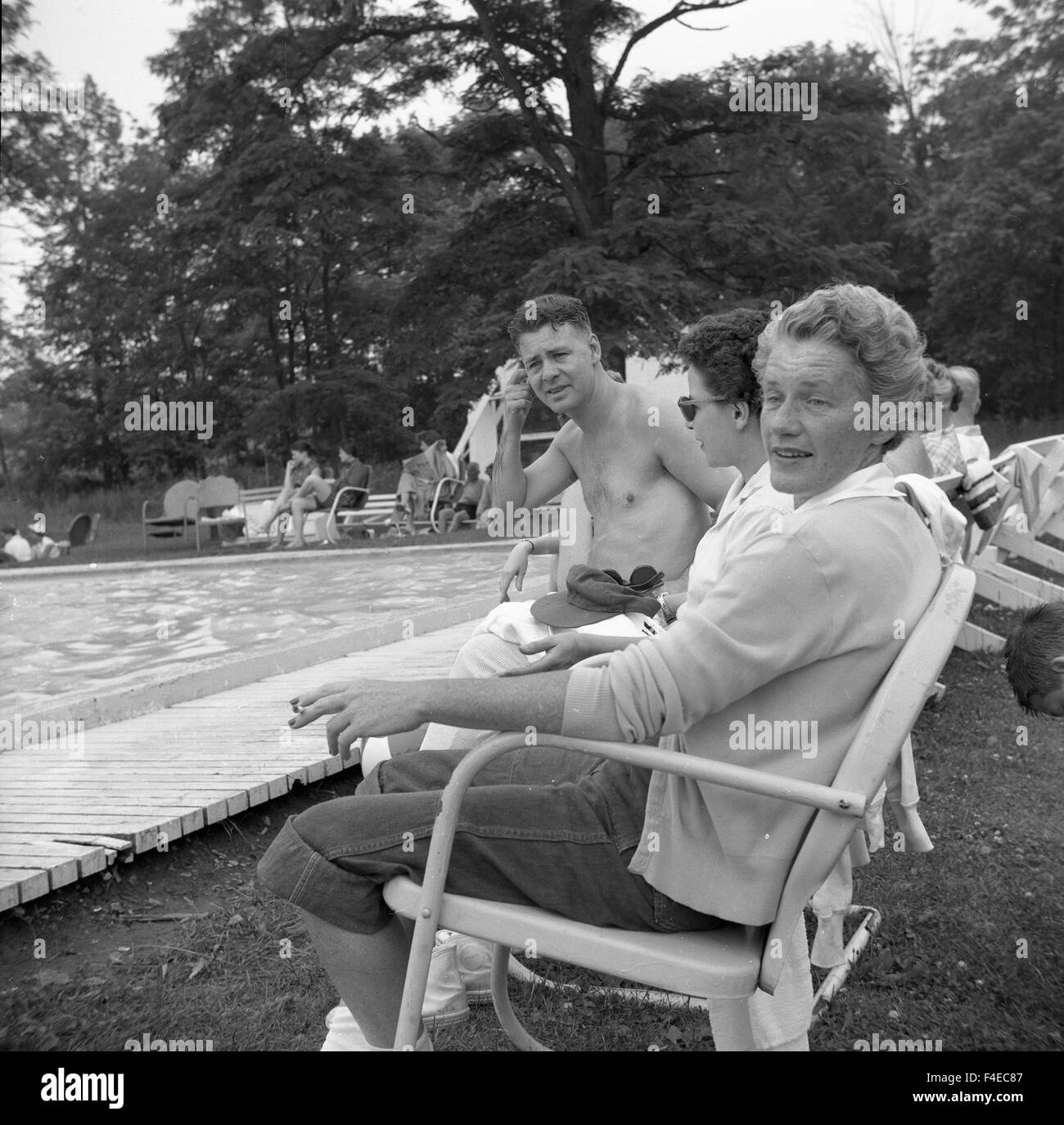 sitting on the edge of a swimming pool during summer in New York Stock ...
