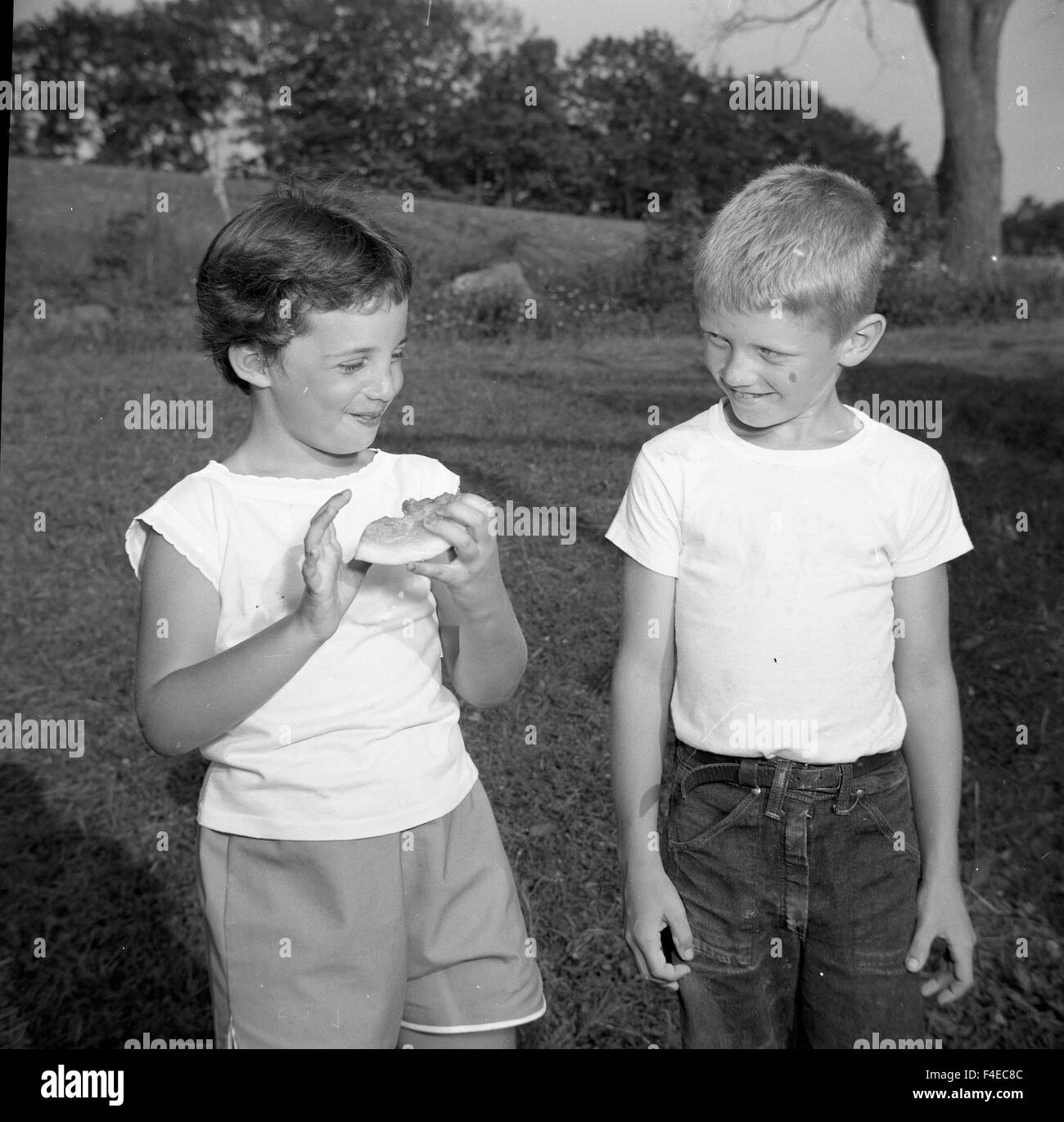 Boy and girl talking during the summer. Girl holding watermelon Stock Photo