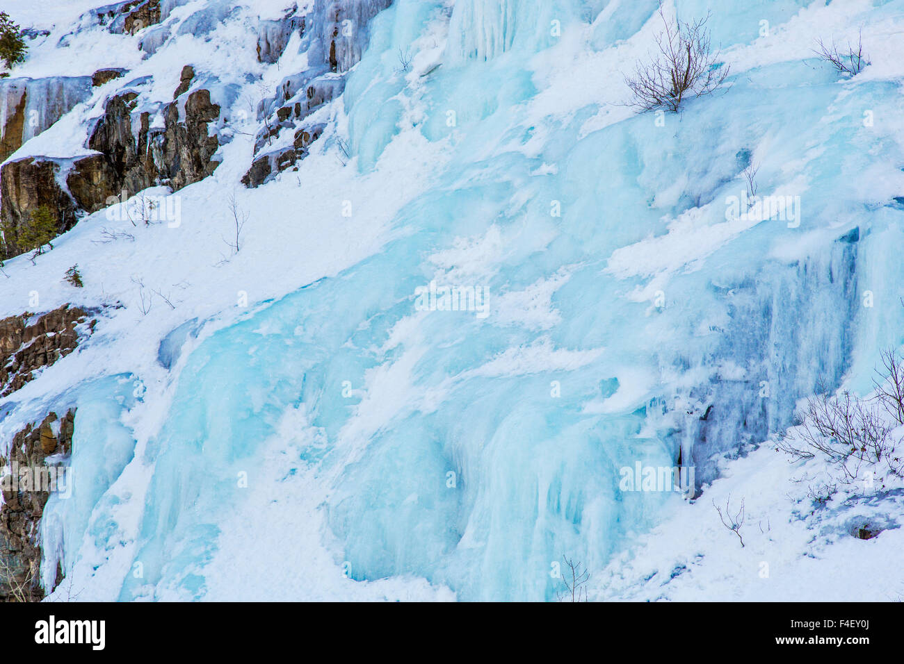 Blue ice seeps from rocks in the Flathead National Forest, Montana, USA. Stock Photo
