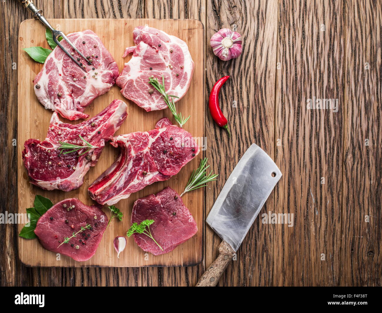 https://c8.alamy.com/comp/F4F38T/raw-meat-steaks-with-spices-on-the-wooden-cutting-board-F4F38T.jpg