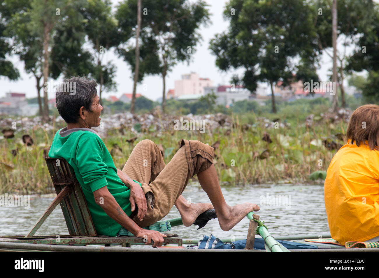 vietnamese man rows with feet tourist boat along ngo dong river at Tam Coc,Ninh Binh,Vietnam Stock Photo