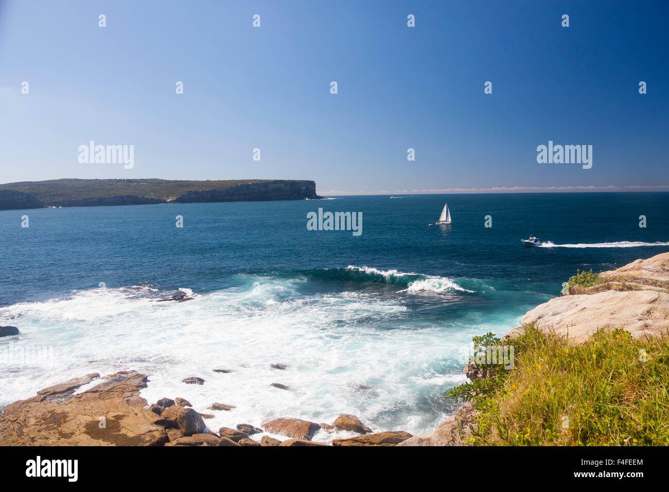 View from South Head to North Head with yacht passing out of Harbour to Pacific Ocean rough water in foreground Sydney New South Stock Photo