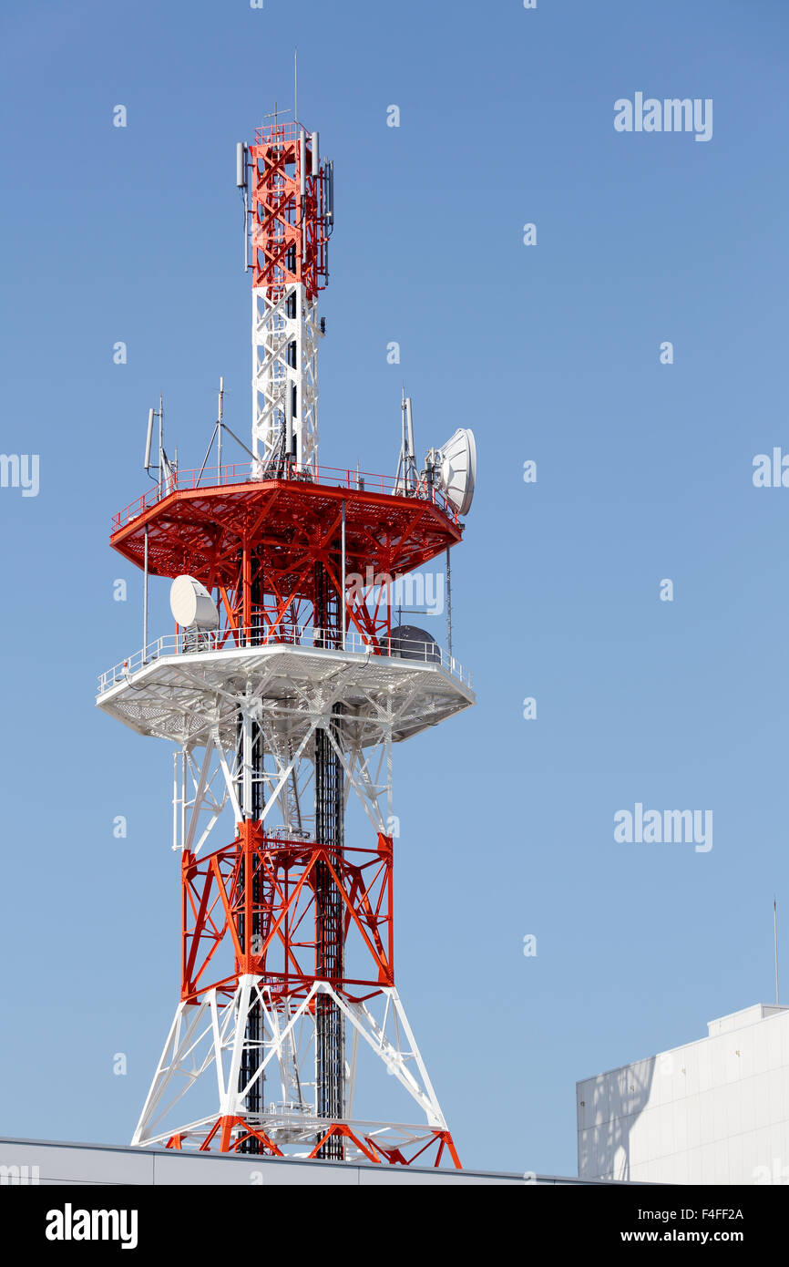 Communications tower with antennas against blue sky Stock Photo