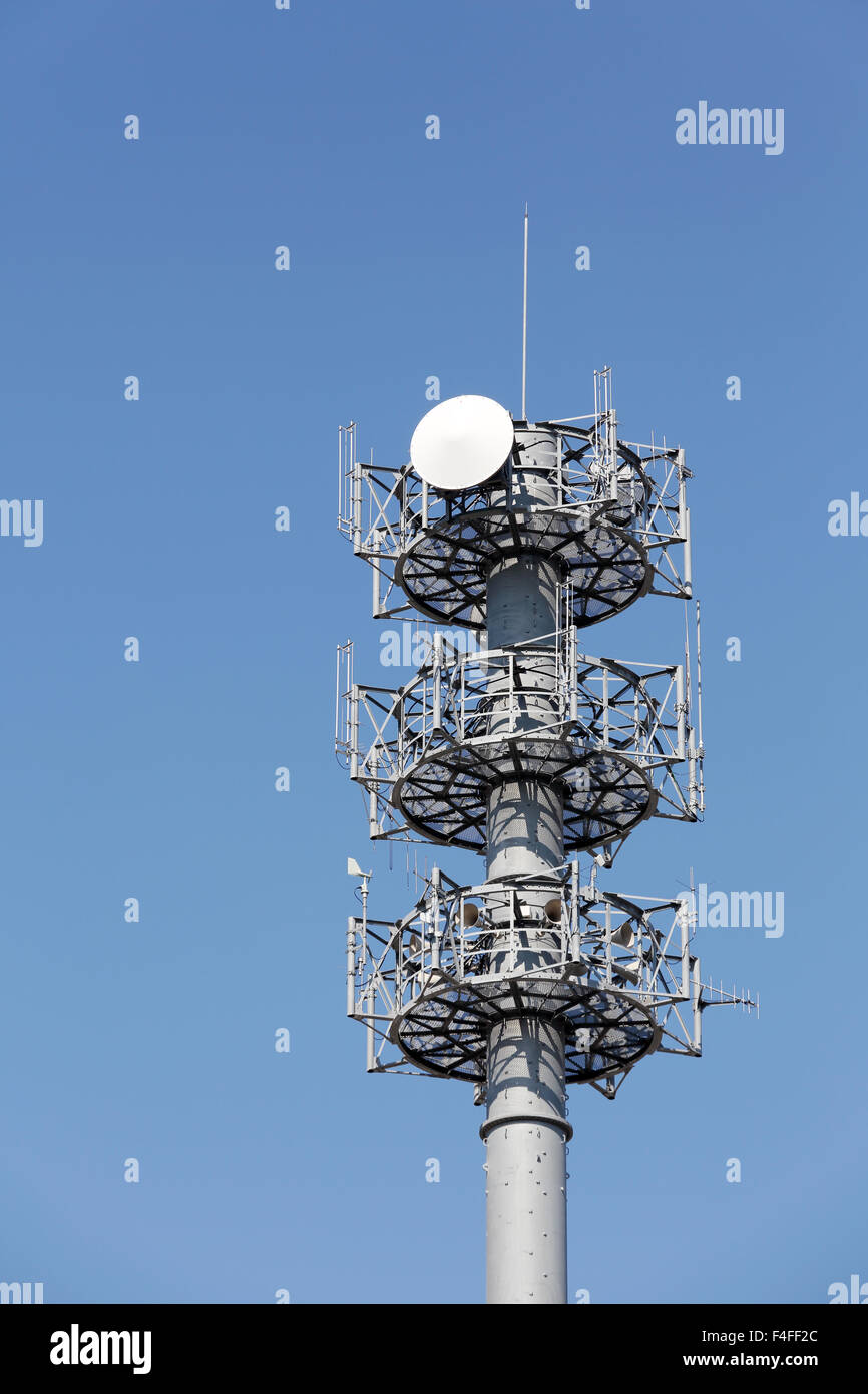 Communications tower with antennas against blue sky Stock Photo