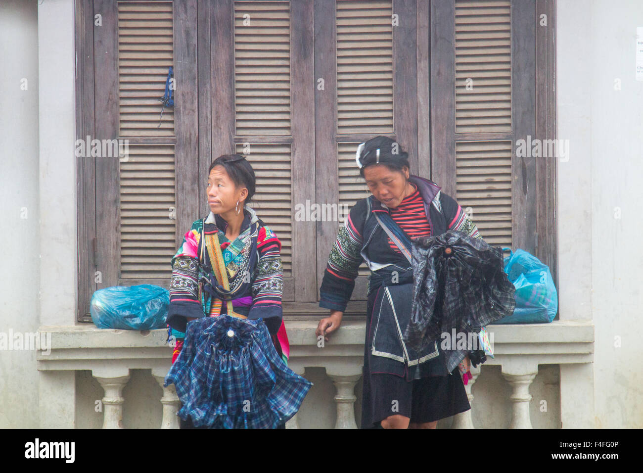 Sapa or Sa Pa is a frontier town in Vietnam, shots here in the rainy wet season, women from black hmong tribe shelter from rain,Vietnam Stock Photo