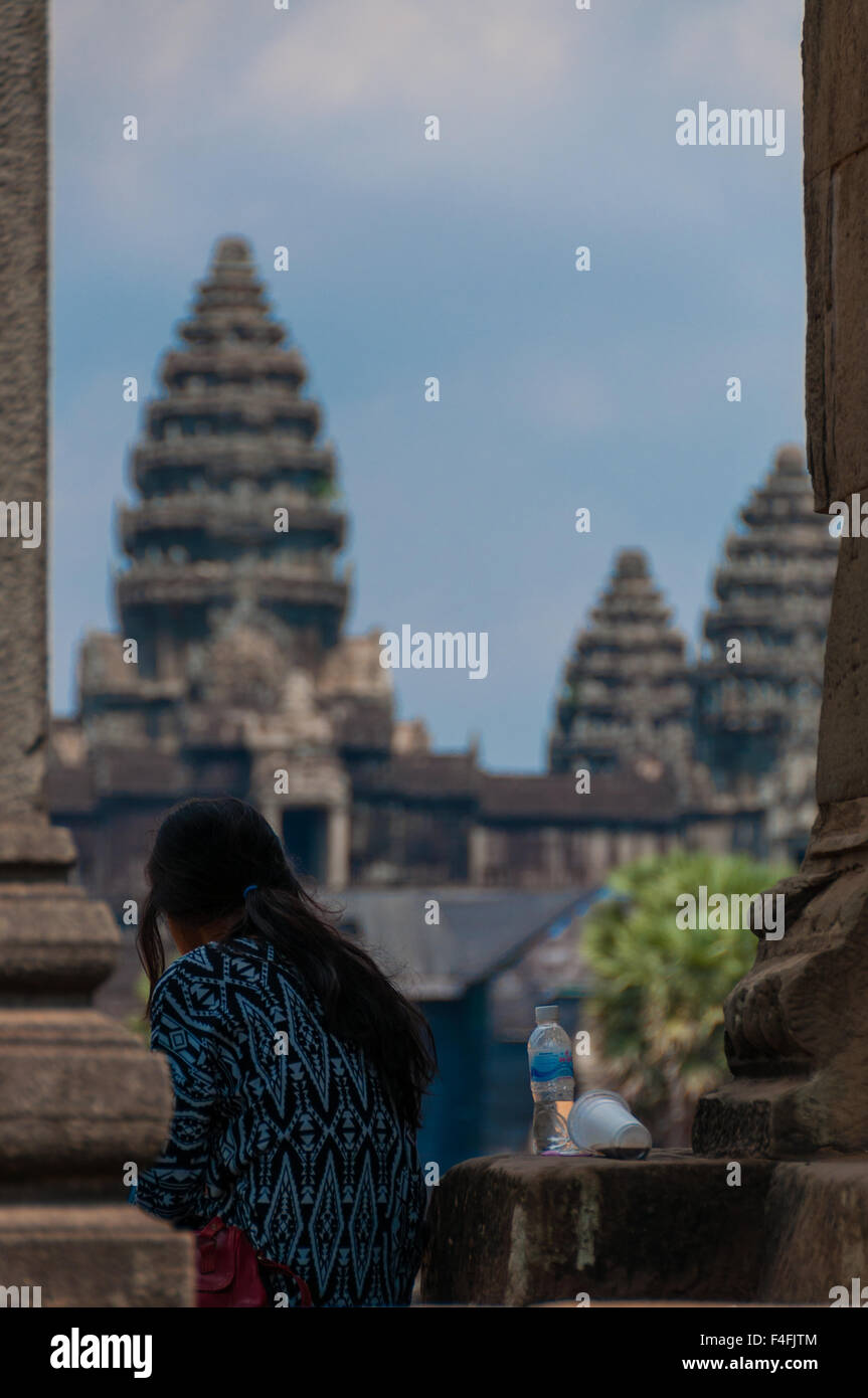 Girl from behind sitting in front of Angkor Wat Stock Photo