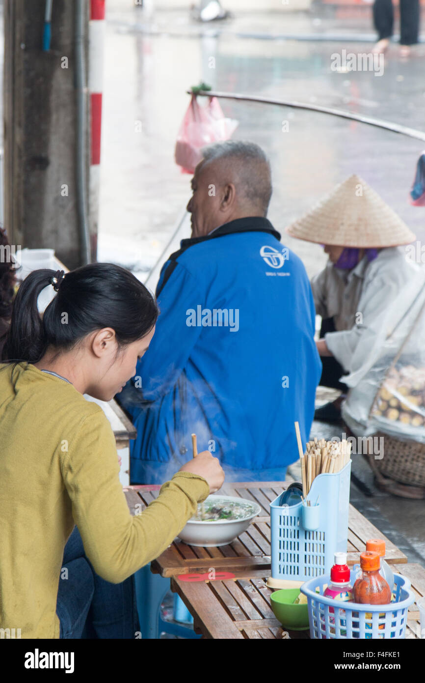 vietnamese lady eating Pho noodle soup,traditional dish,for breakfast in Ta Hien street, Hanoi