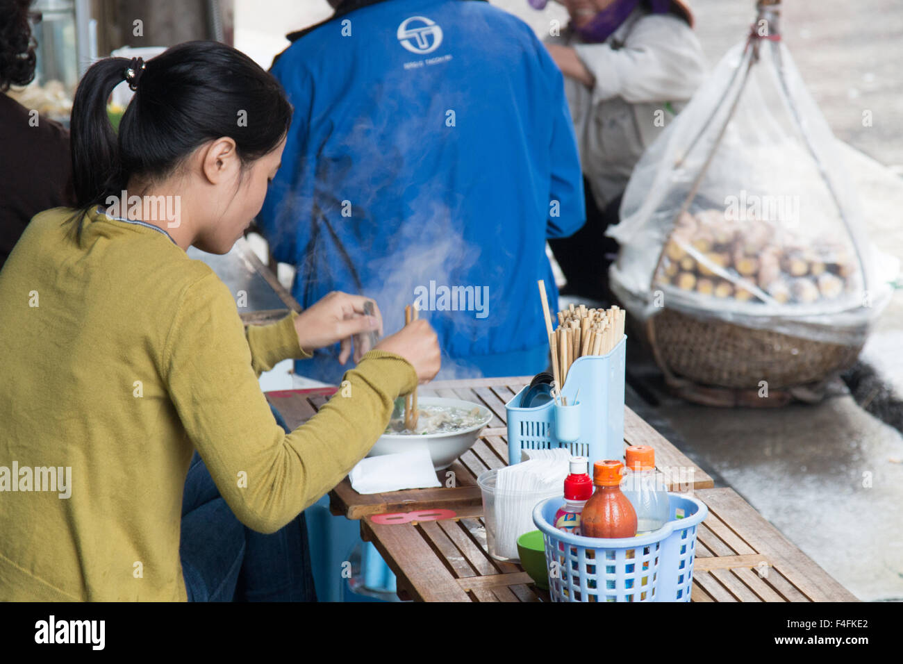 vietnamese lady eating Pho noodle soup,traditional dish,for breakfast in Ta Hien street, Hanoi
