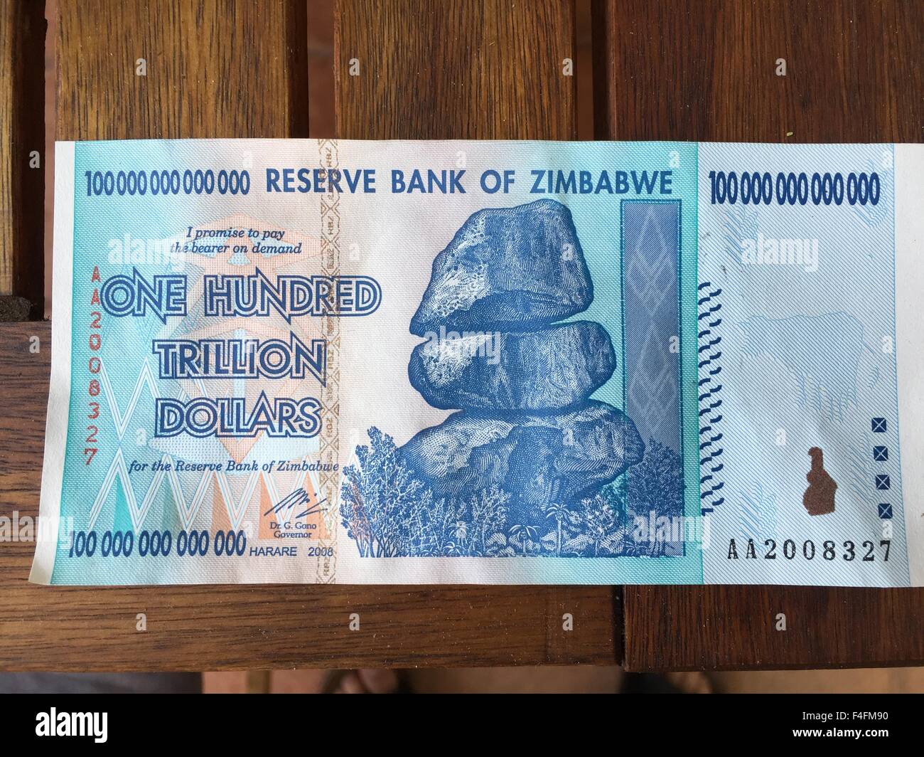 A banknote from Zimbabwe worth one hundred trillion Zimbabwean dollars has been laid out on a