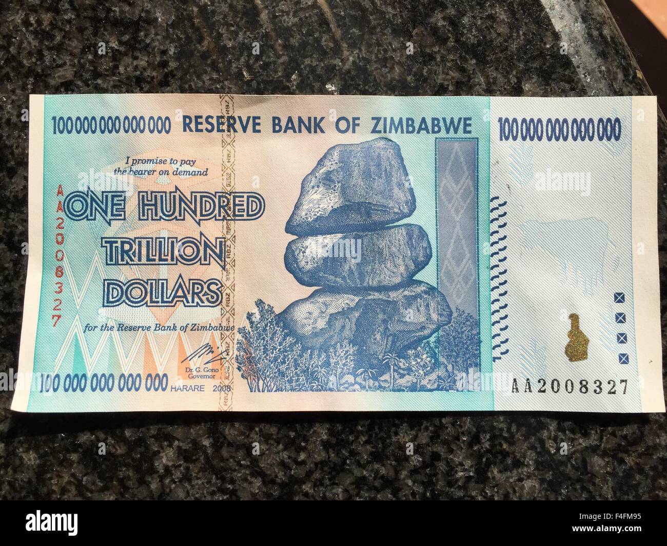 A banknote from Zimbabwe worth one hundred trillion Zimbabwean dollars has been laid out on a