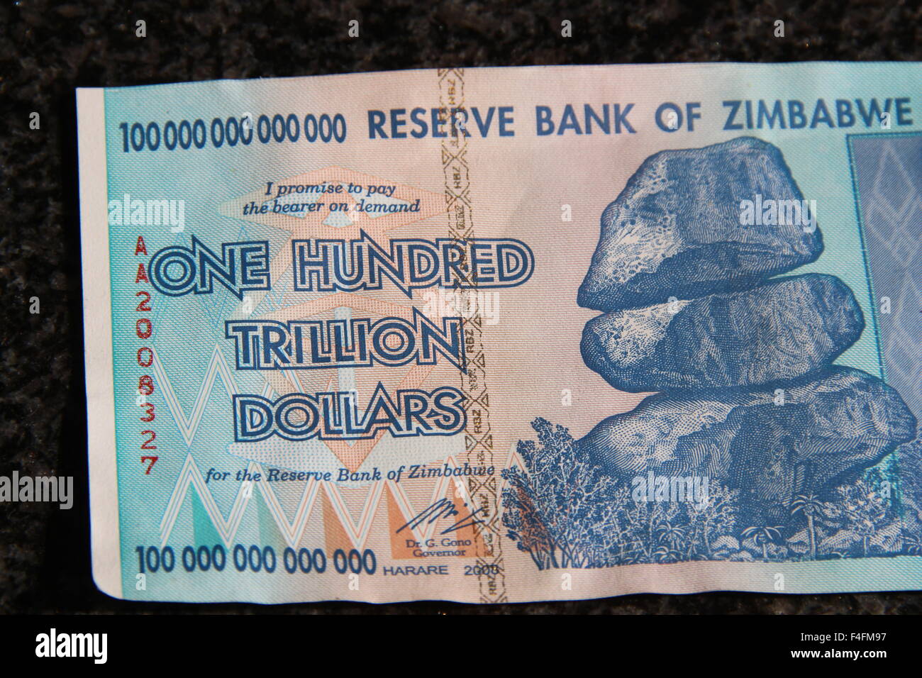 A banknote from Zimbabwe worth one hundred trillion Zimbabwean dollars has been laid out on a