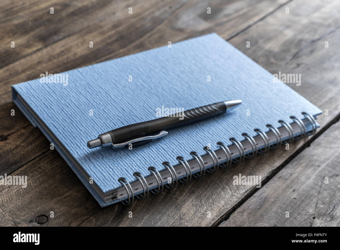 Blue notebook and pen on wooden table, close up Stock Photo