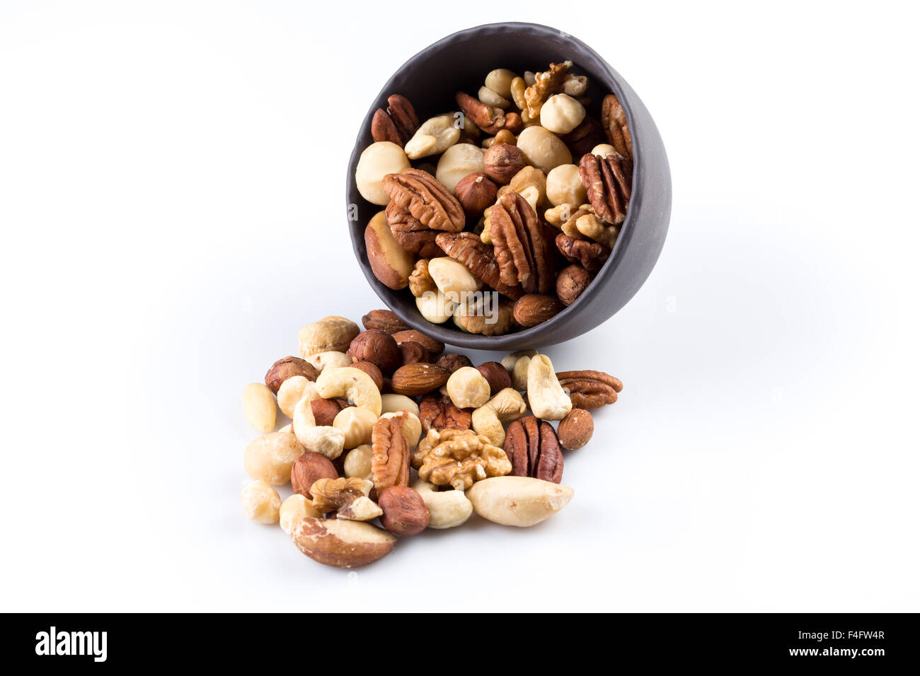 Large diversity of healthy nuts in a dark bowl - isolated Stock Photo