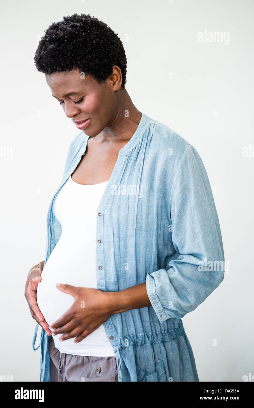 Pregnant woman holding her stomach Stock Photo - Alamy