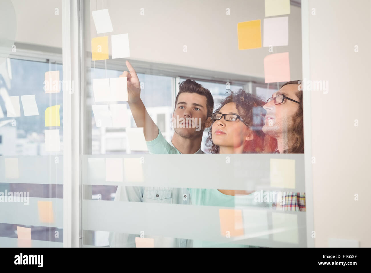 Businesswoman pointing at sticky notes in creative office Stock Photo ...