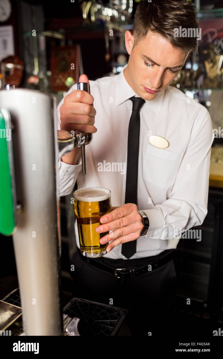 Well dressed bartender serving beer Stock Photo