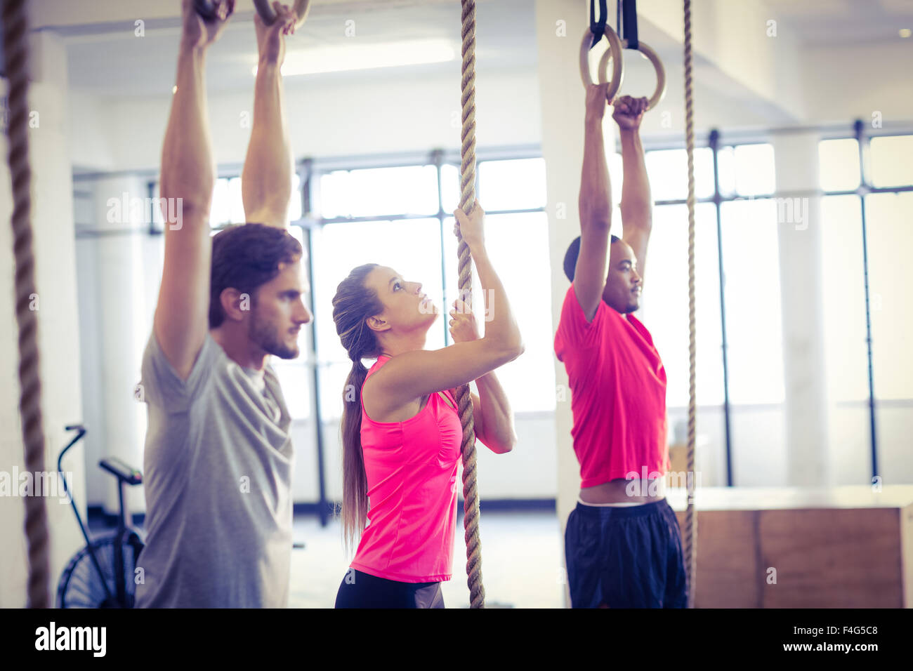 Athletes doing ring gymnastics and climbing rope Stock Photo