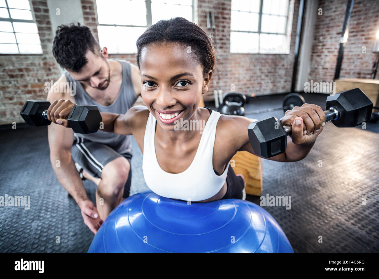 Personal trainer working with client holding dumbbell Stock Photo