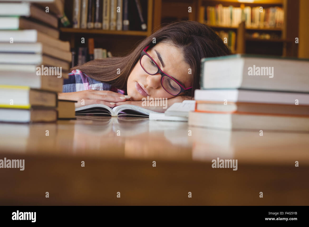Female student napping with head on book Stock Photo