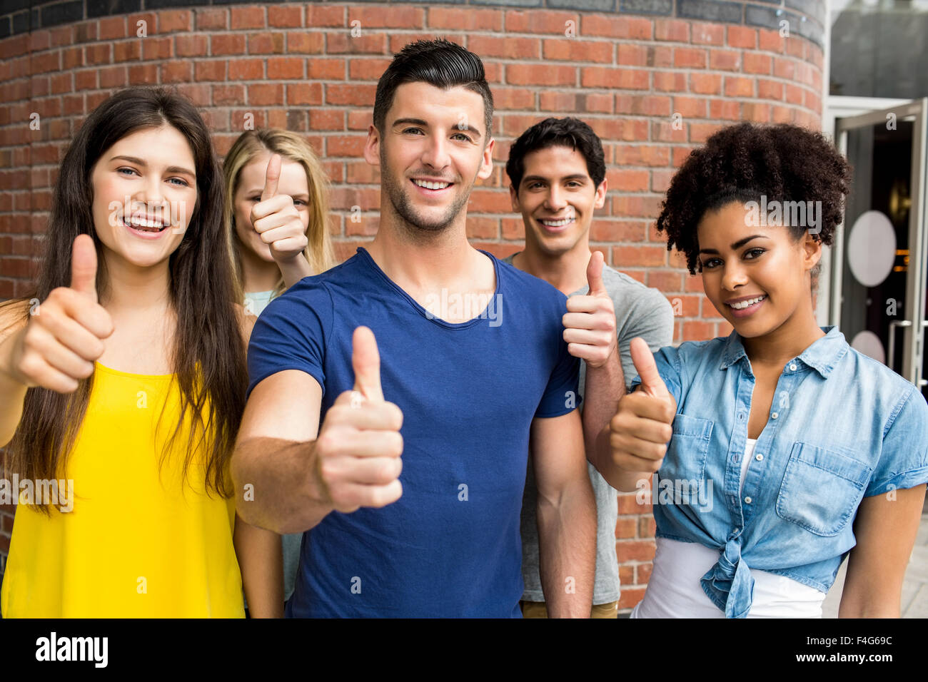 Students all showing thumbs up together Stock Photo