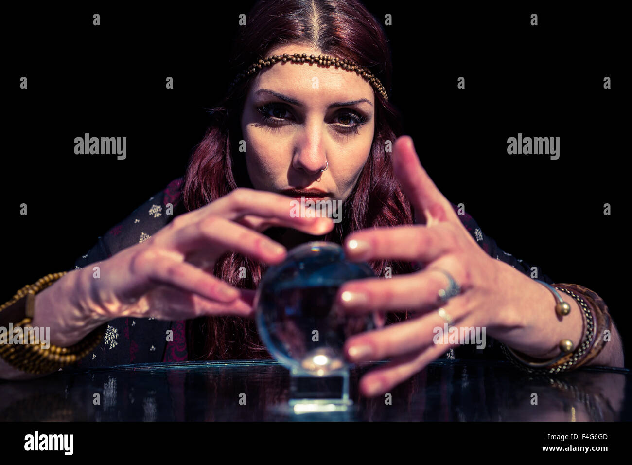 Portrait of woman using crystal ball Stock Photo