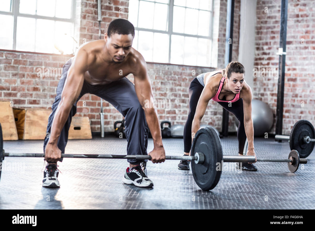 Fit couple lifting weight together Stock Photo - Alamy