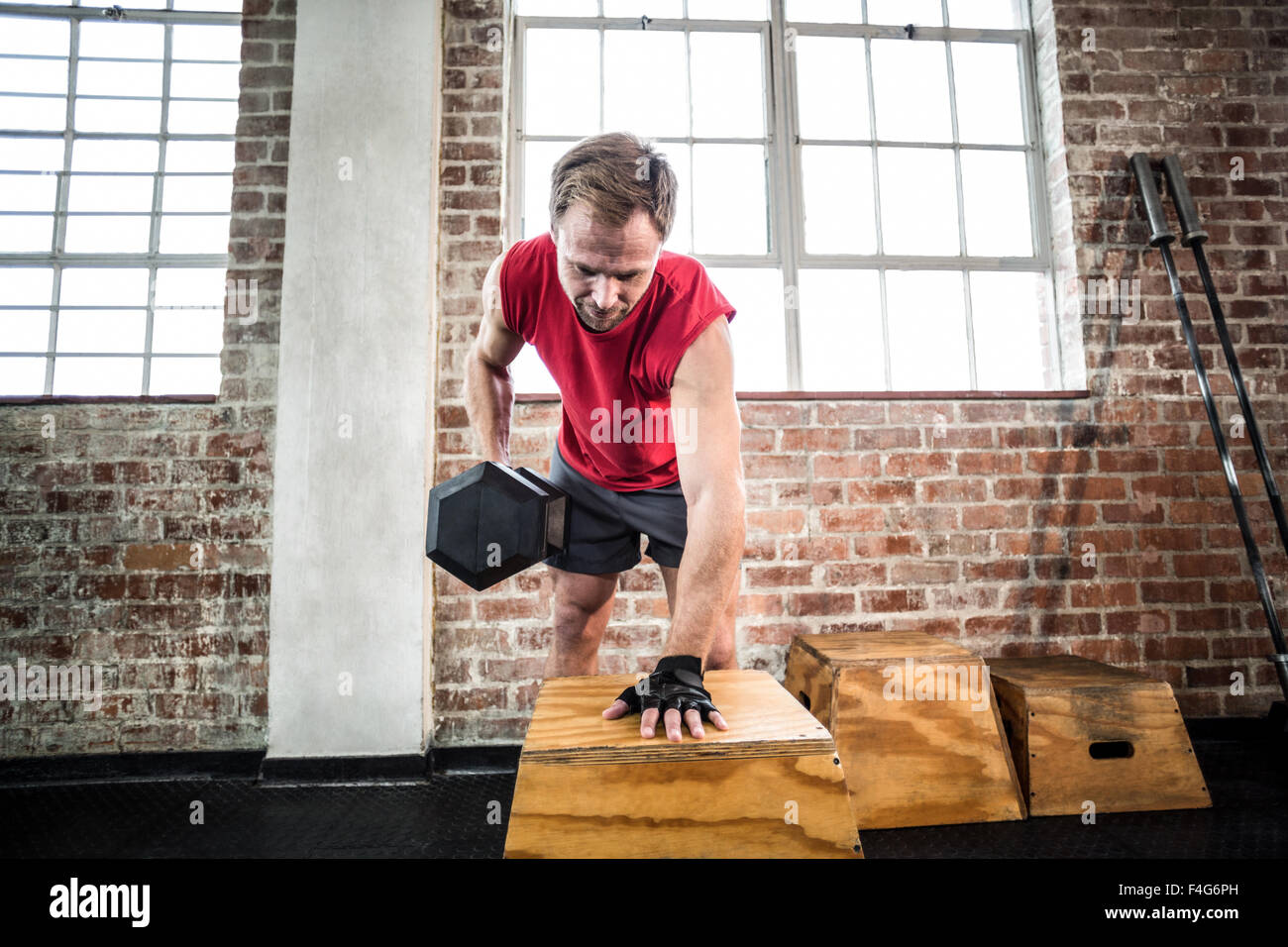 Muscular man lifting dumbbell lean on a box Stock Photo