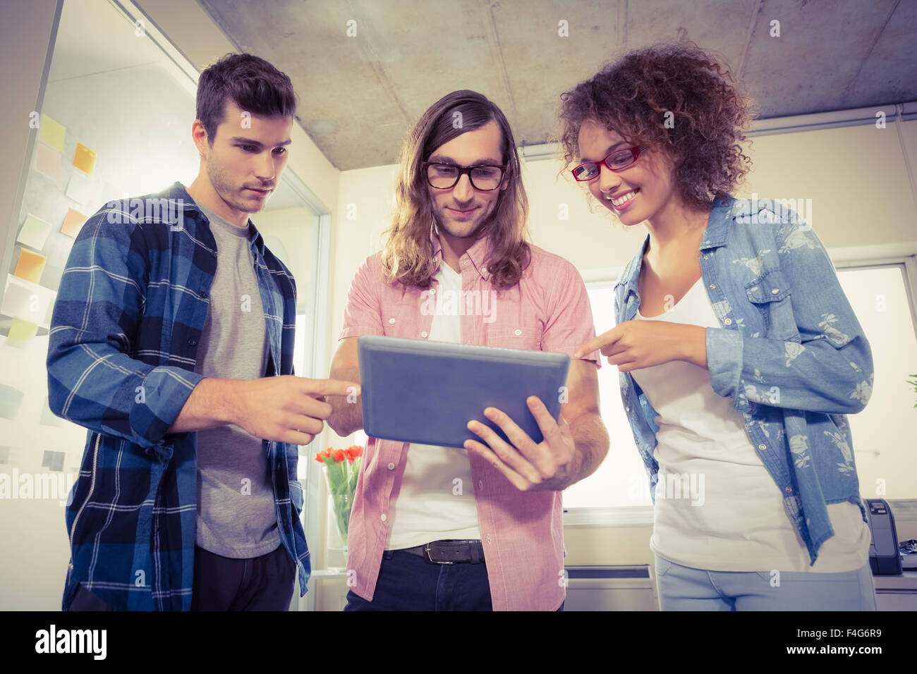 Smiling business people discussing over digital tablet Stock Photo